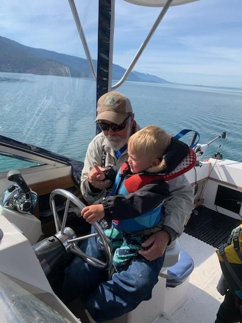 A man is holding a little boy on a boat