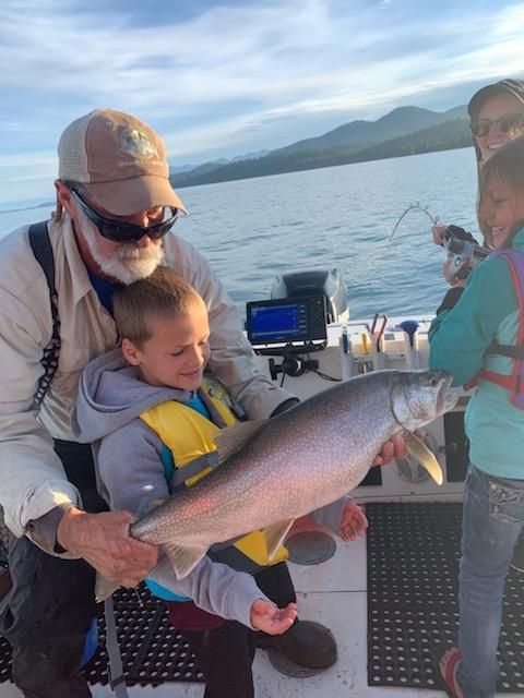 A man is holding a fish while a child looks on