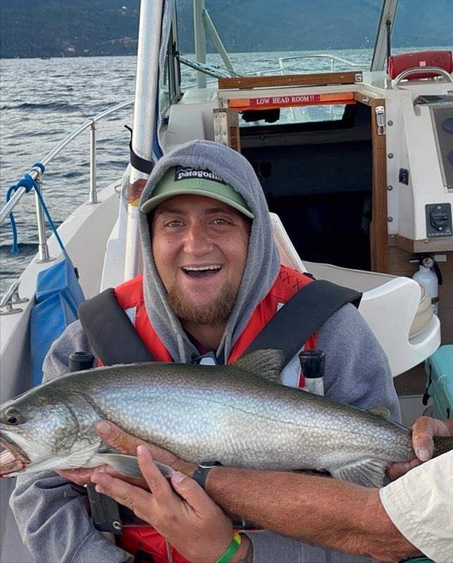 A man is holding a large fish on a boat