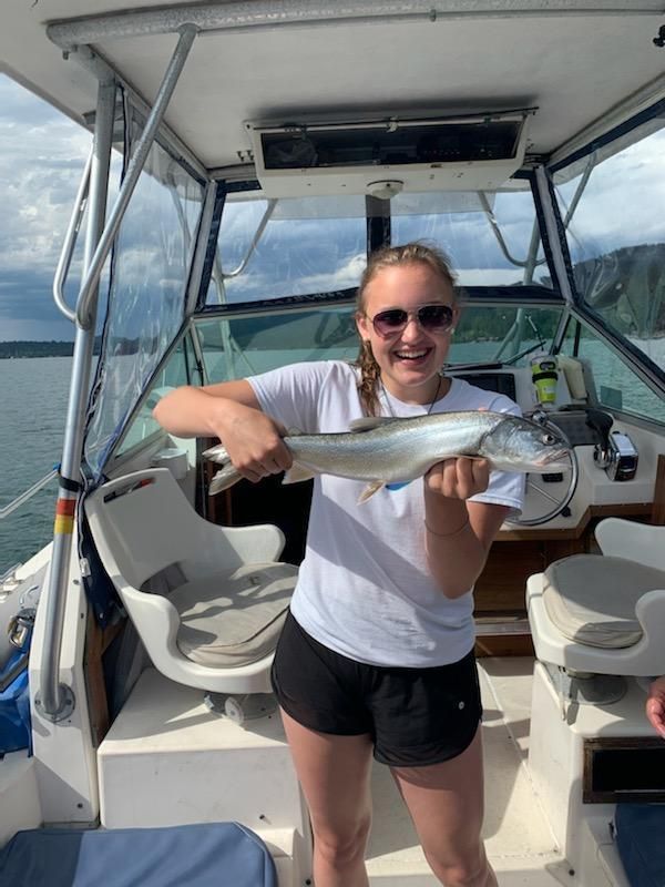 A woman is holding a fish on a boat.