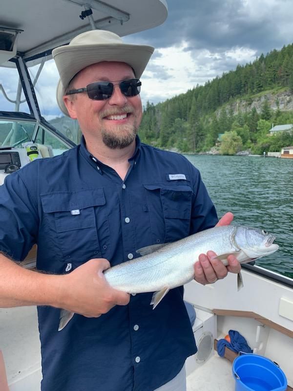 A man is holding a fish on a boat.