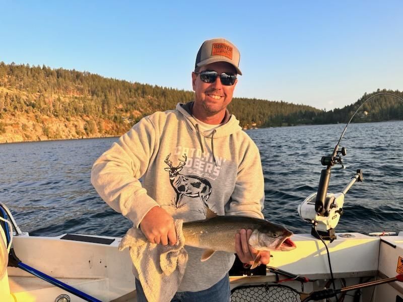 A man is holding a fish on a boat.