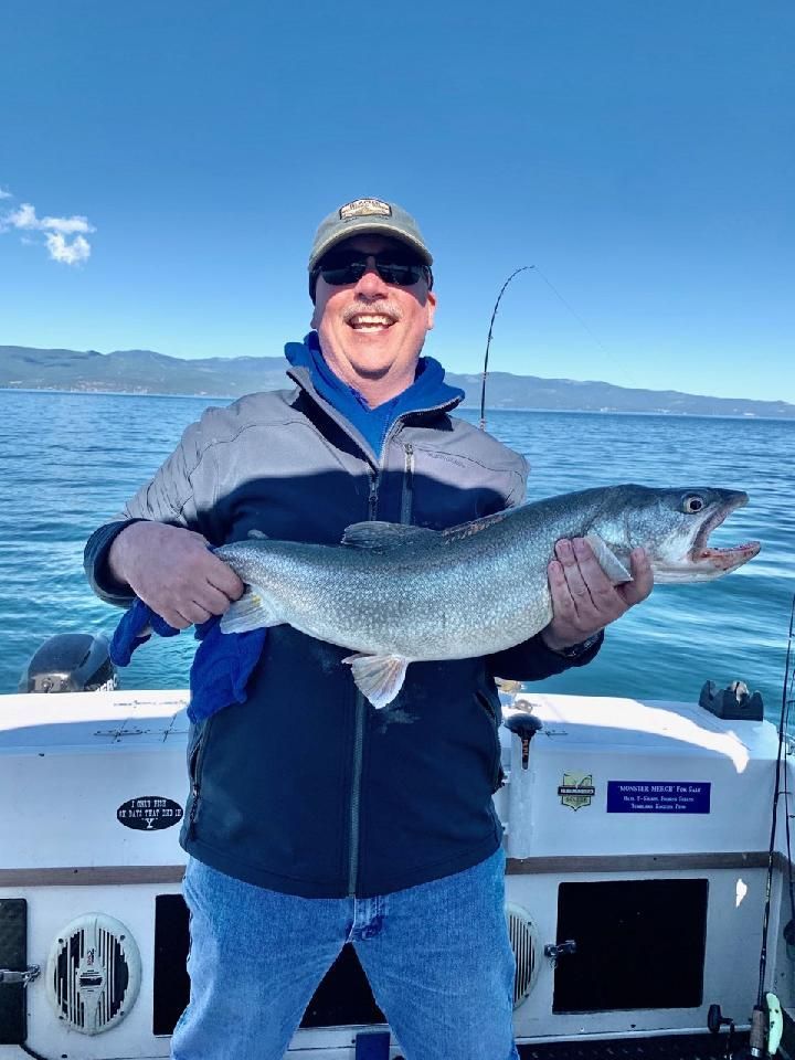 A man is holding a large fish on a boat