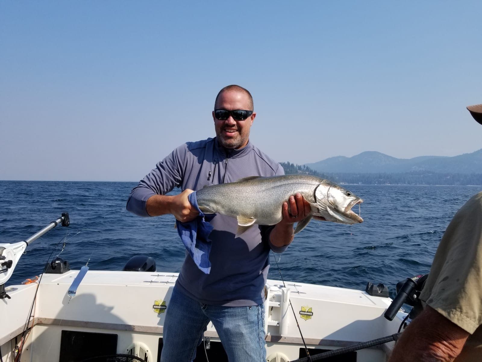 A man is holding a large fish on a boat.