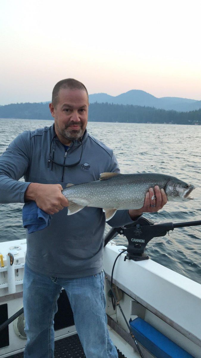 A man is holding a large fish on a boat.