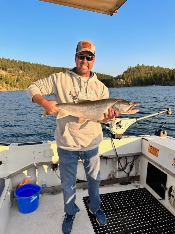 A man is holding a large fish on a boat