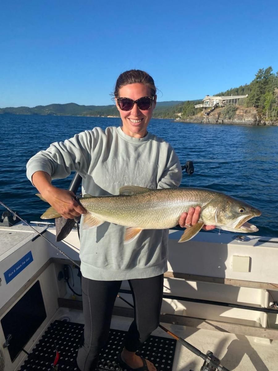 A woman is holding a large fish on a boat.