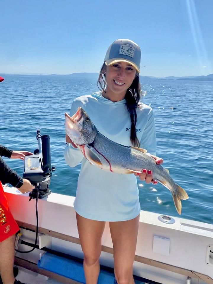 A woman is holding a large fish on a boat.
