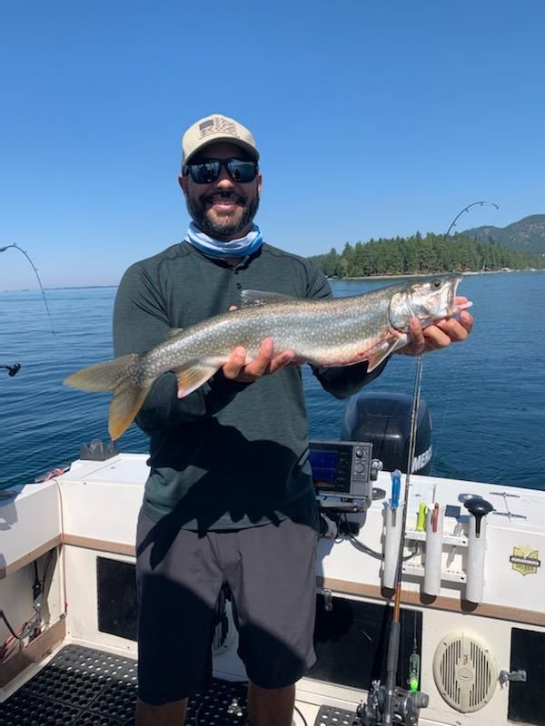 A man on a boat holding a fish in his hands