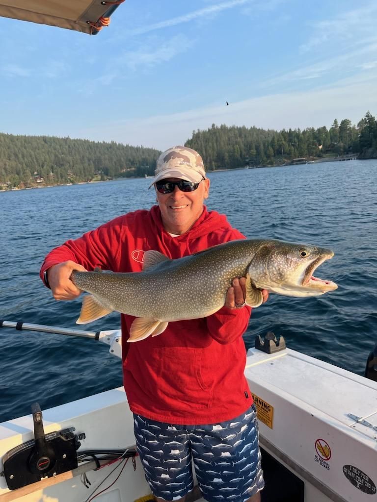 A man is holding a large fish on a boat.