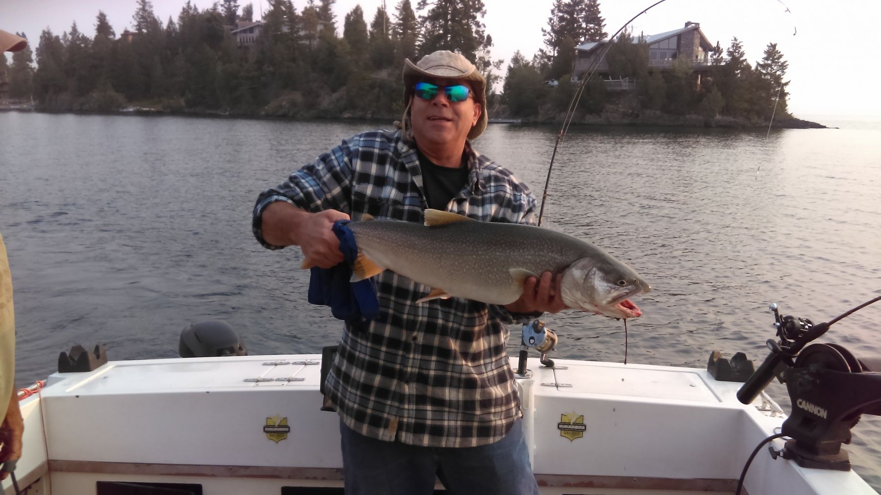 A man is holding a large fish on a boat.