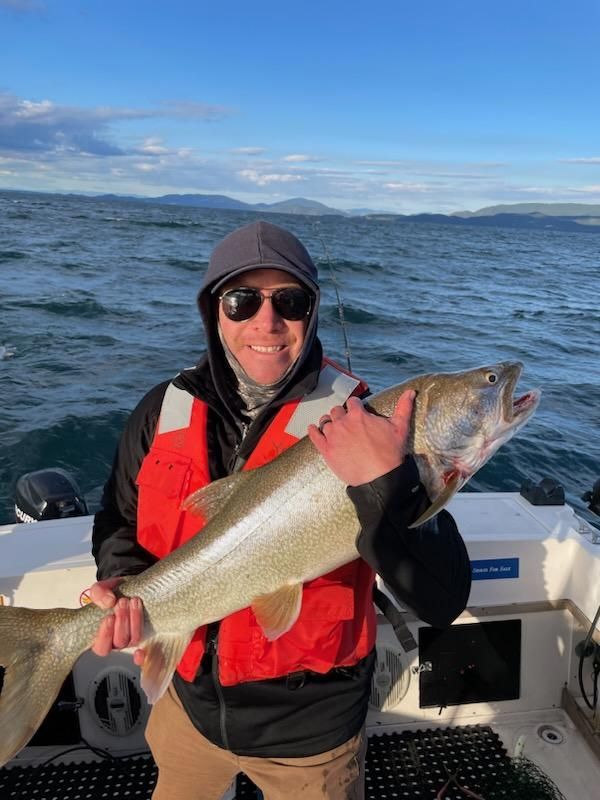 A man is holding a large fish on a boat.