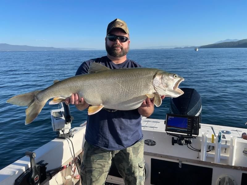 A man is holding a large fish on a boat.
