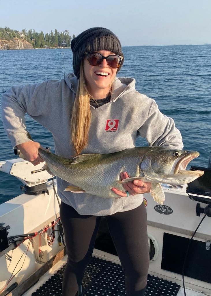A woman is holding a large fish on a boat.