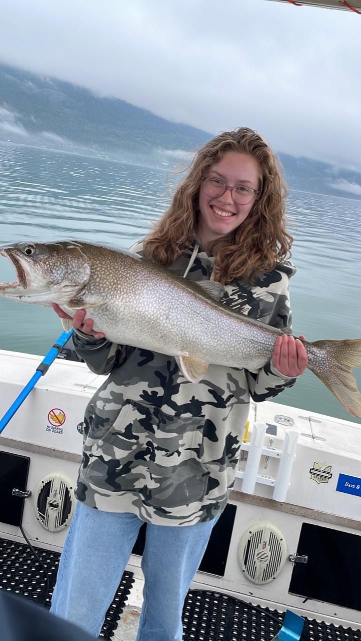 A woman is holding a large fish on a boat.