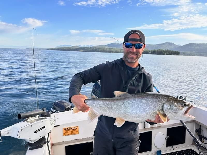 A man is holding a large fish on a boat.