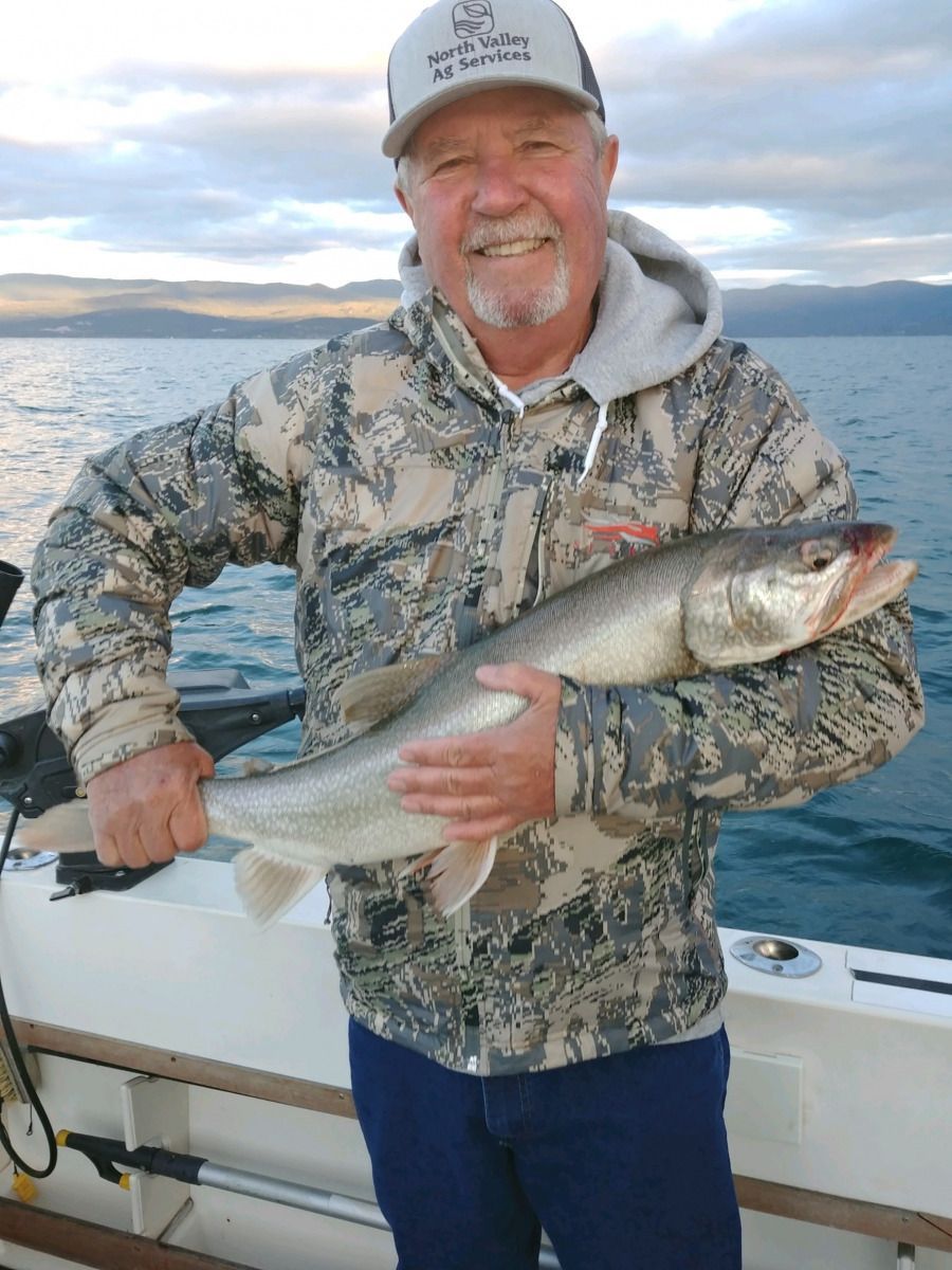 A man is holding a large fish on a boat.