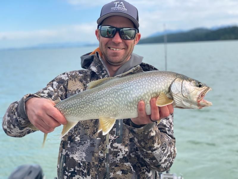 A man is holding a large fish in his hands.