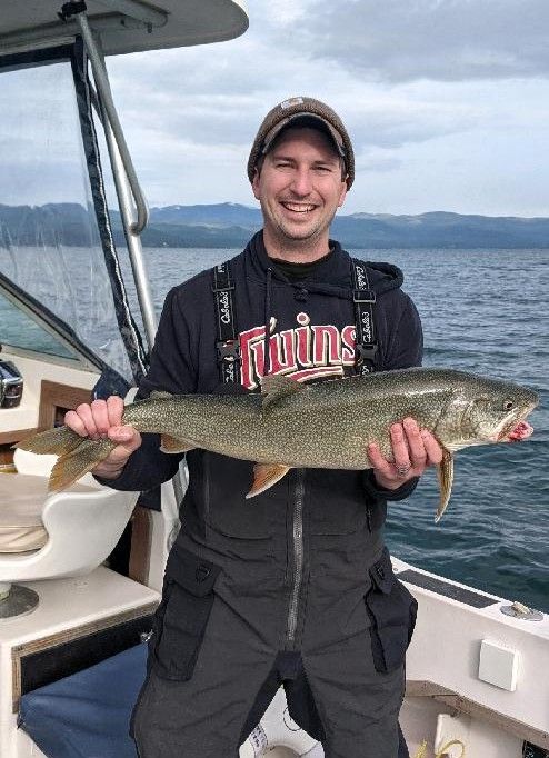 A man is holding a large fish on a boat.