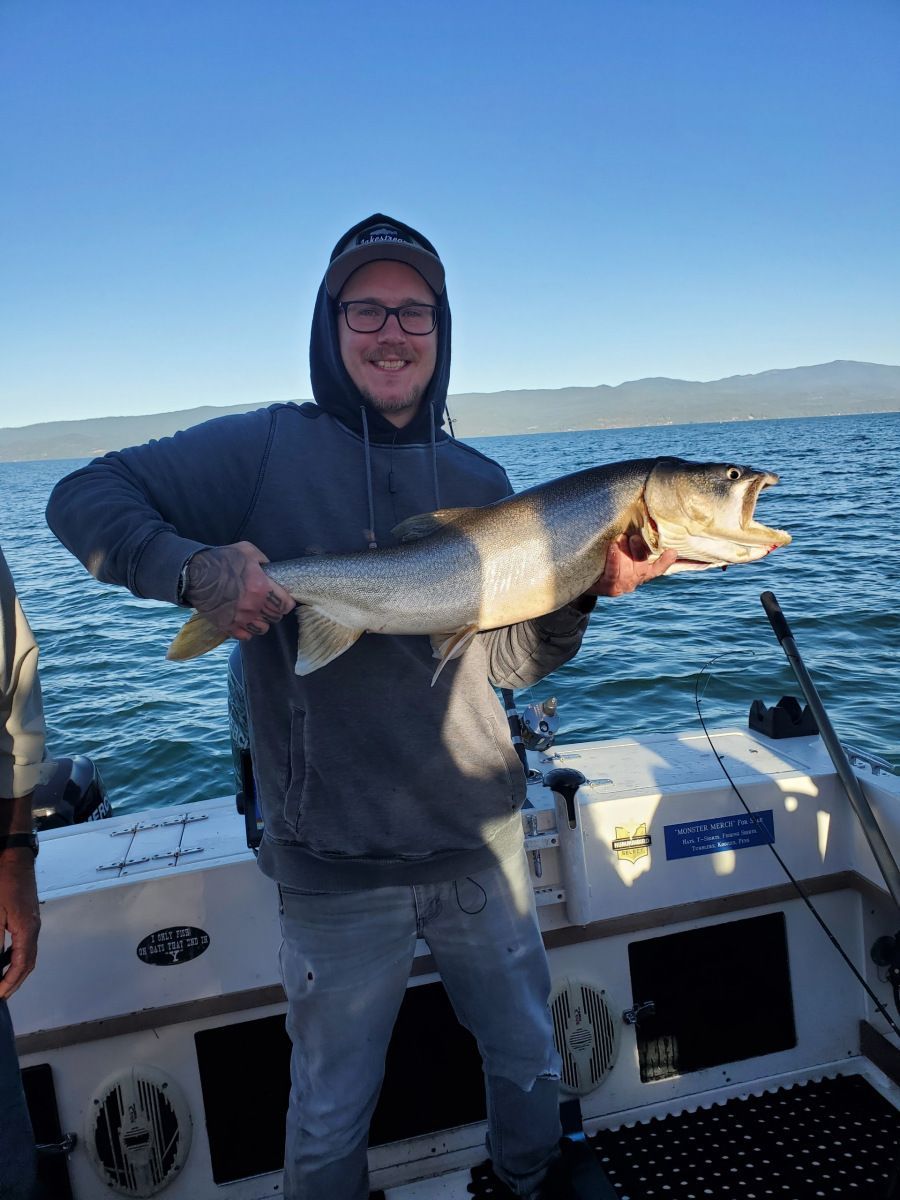 A man is holding a large fish on a boat.