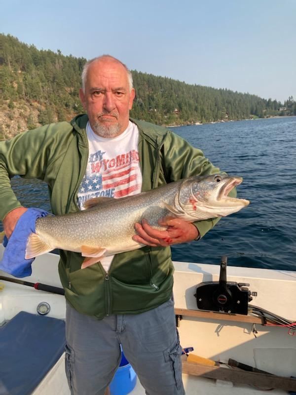A man is holding a large fish on a boat.