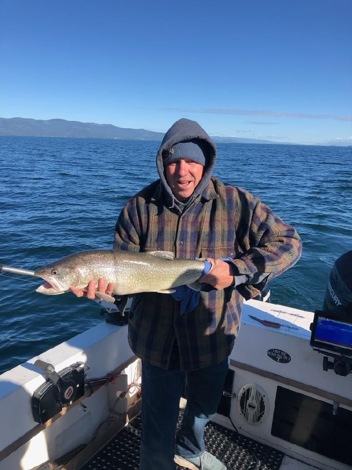 A man is holding a large fish on a boat.