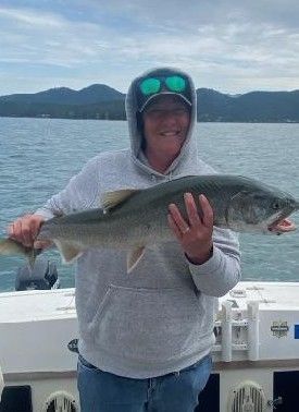 A woman is holding a large fish on a boat.