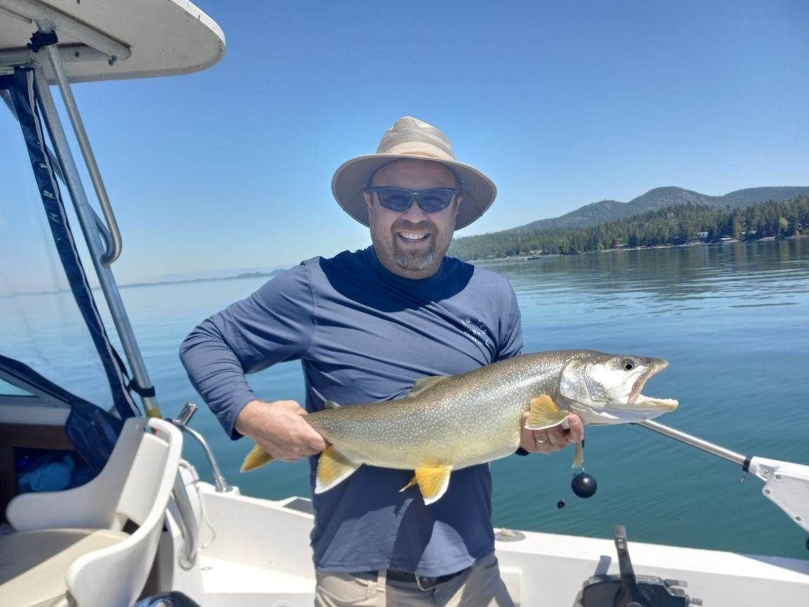 A man on a boat holding a large fish