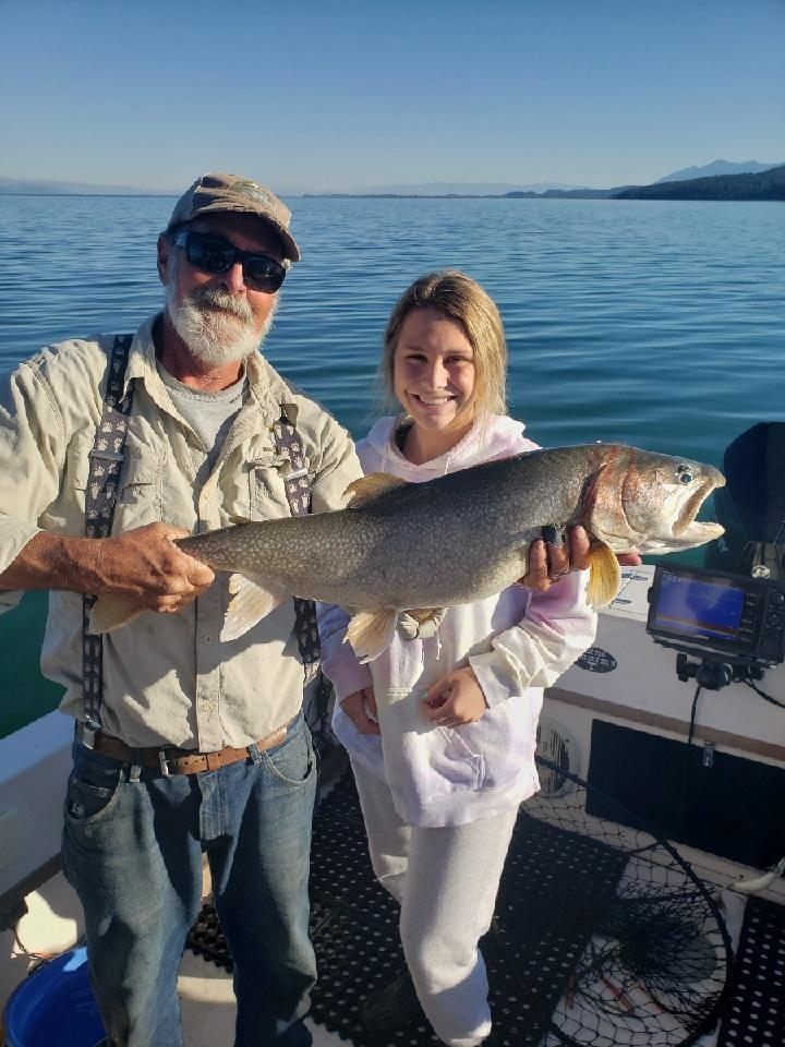 A man and a woman are holding a large fish on a boat.