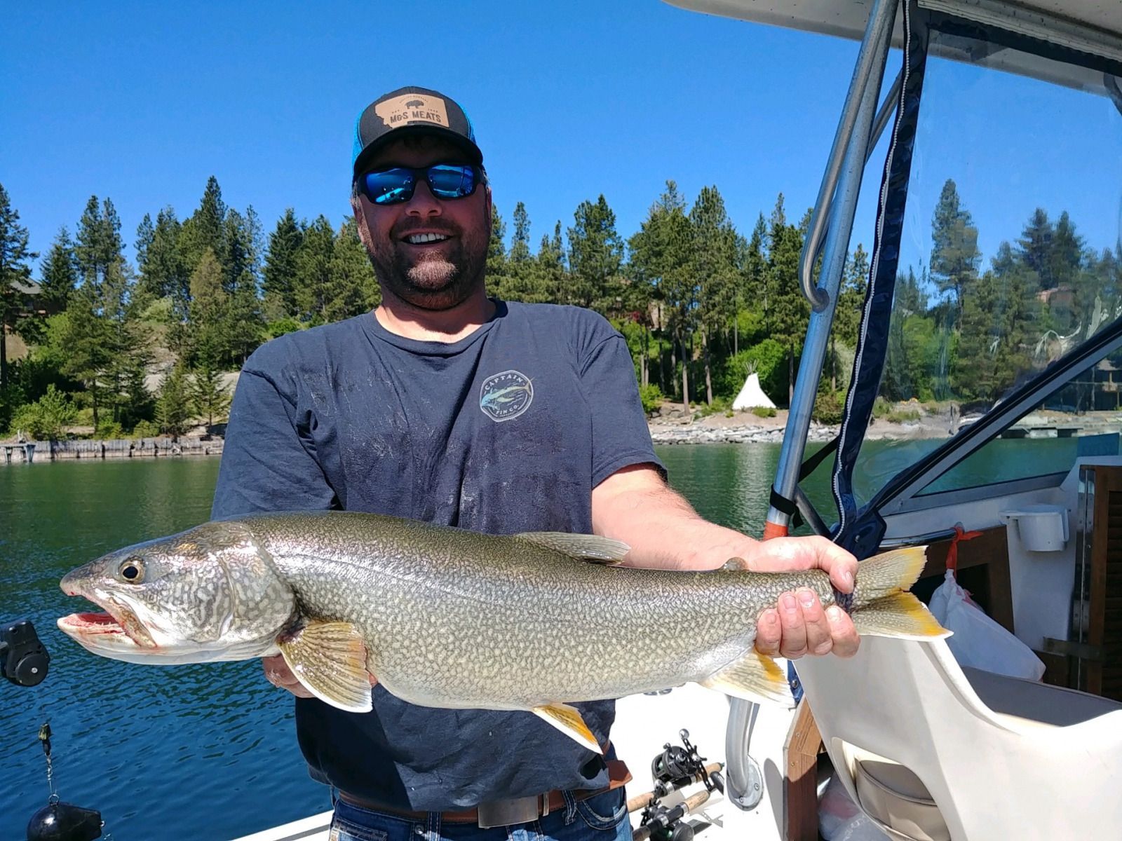 A man is holding a large fish on a boat