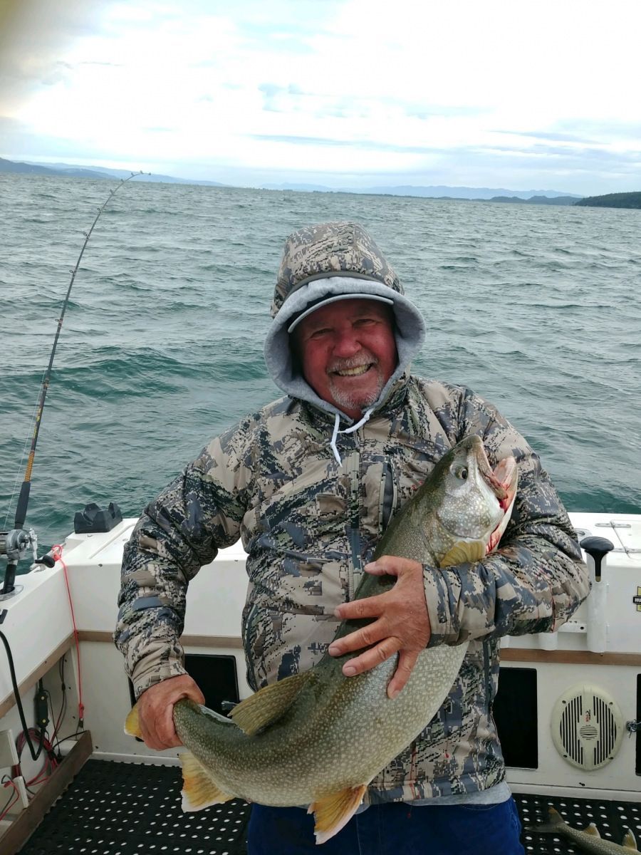 A man is holding a large fish on a boat.