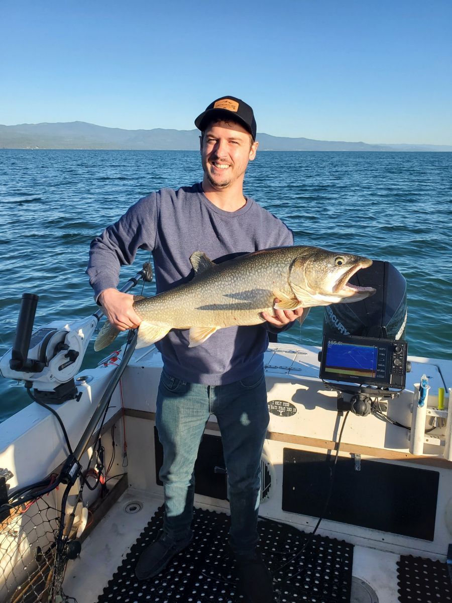 A man is holding a large fish on a boat.