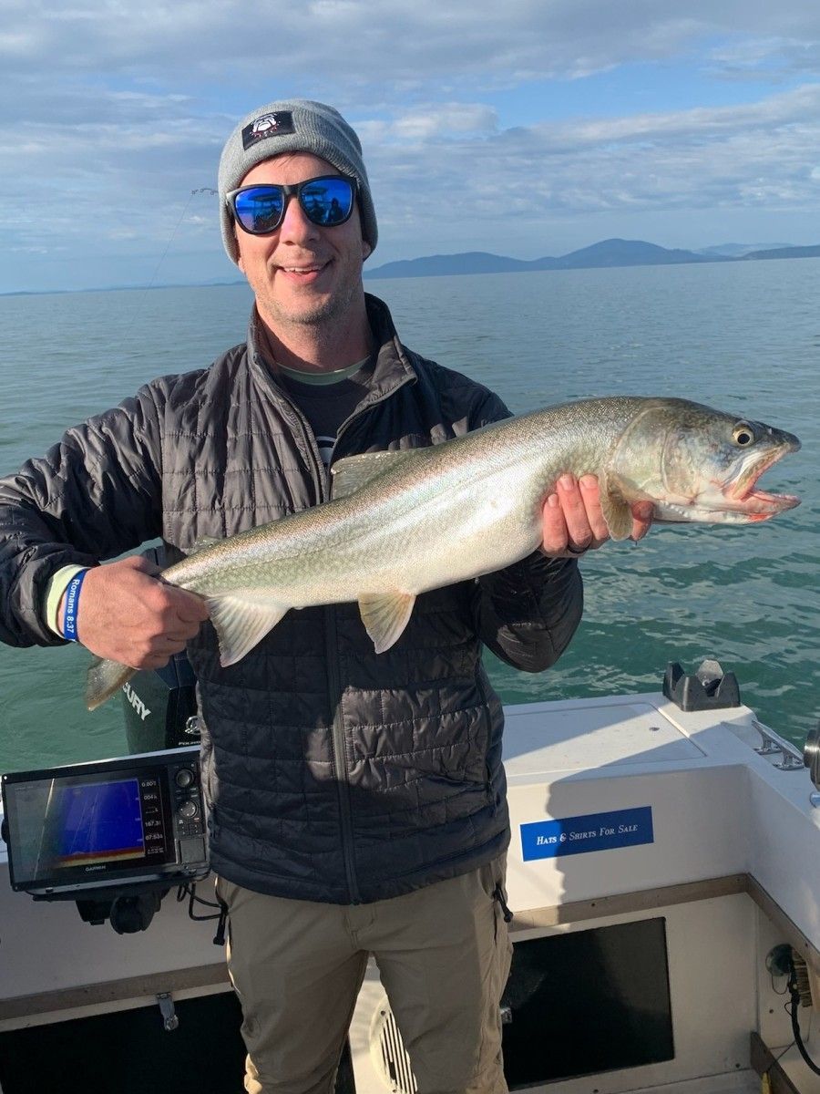 A man is holding a large fish on a boat.