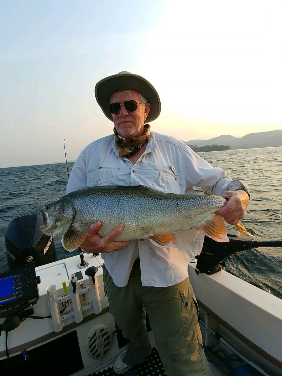 A man is holding a large fish on a boat.