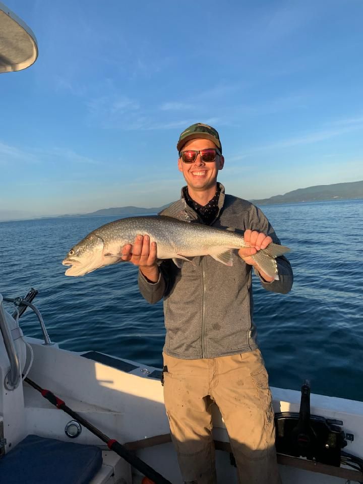 A man is holding a large fish on a boat.