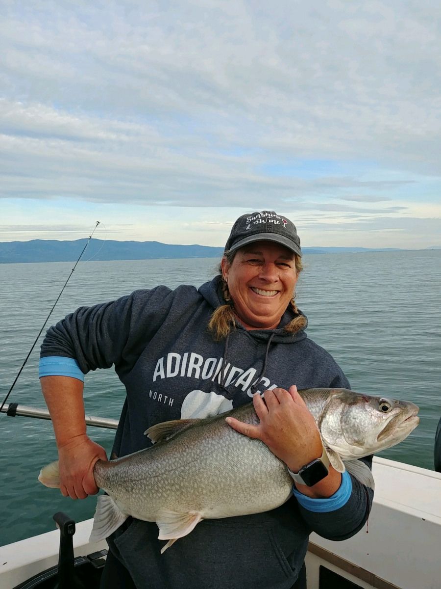 A woman is holding a large fish on a boat.