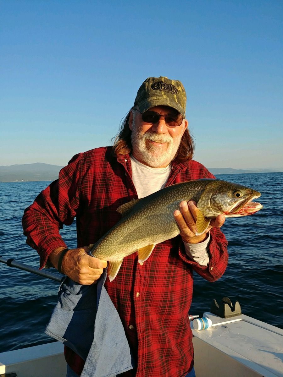 A man is holding a fish in his hands on a boat.