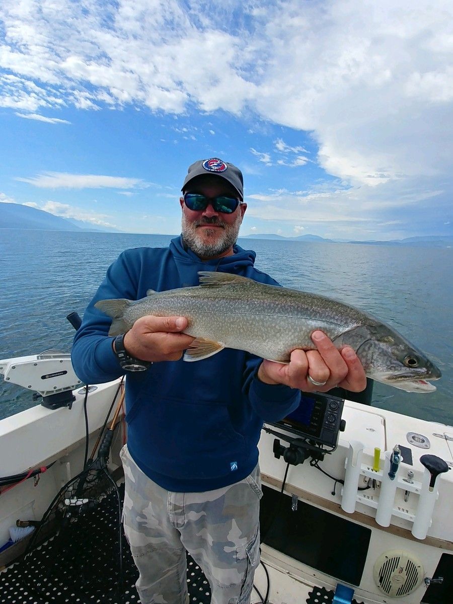 A man is holding a fish in his hands on a boat.