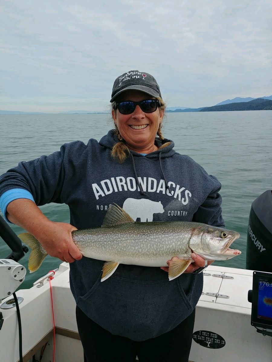 A woman is holding a large fish on a boat.