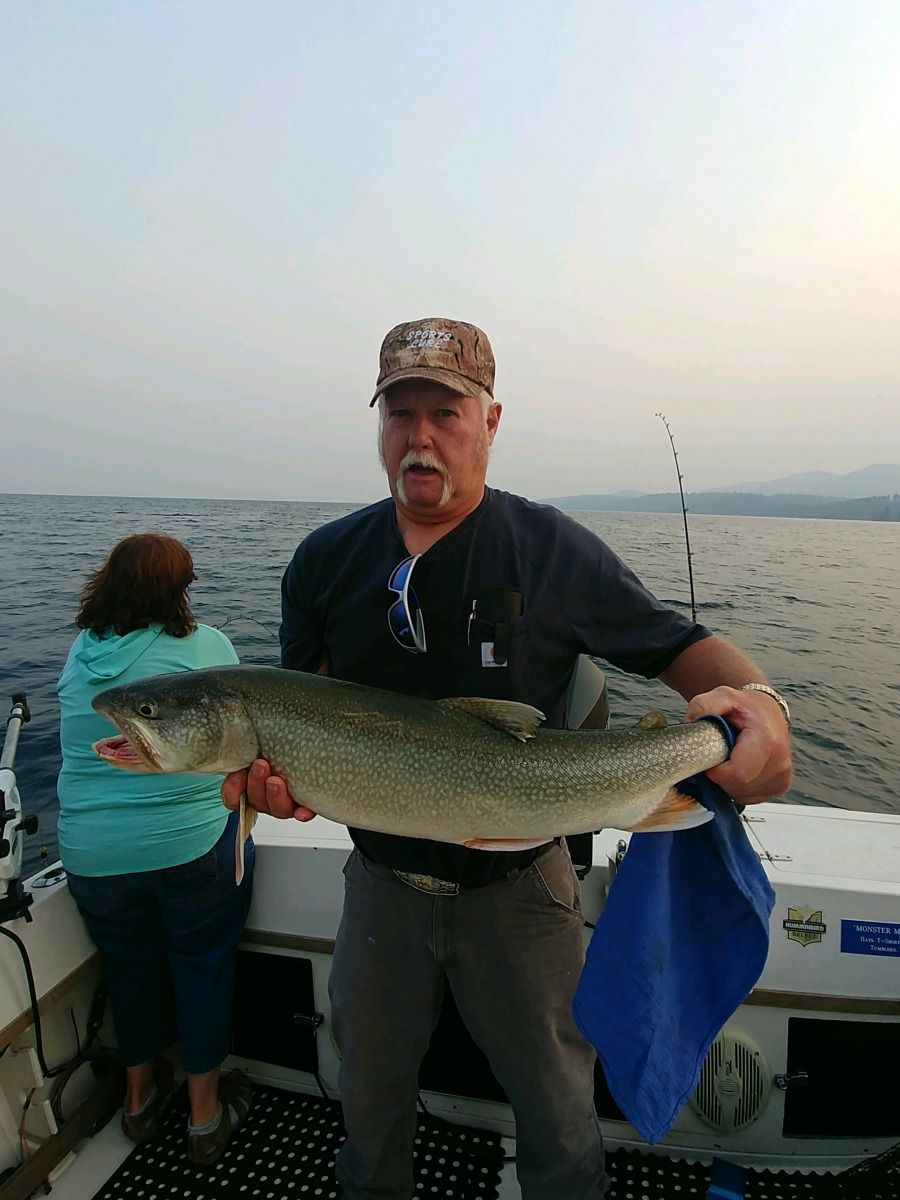 A man is holding a large fish on a boat.
