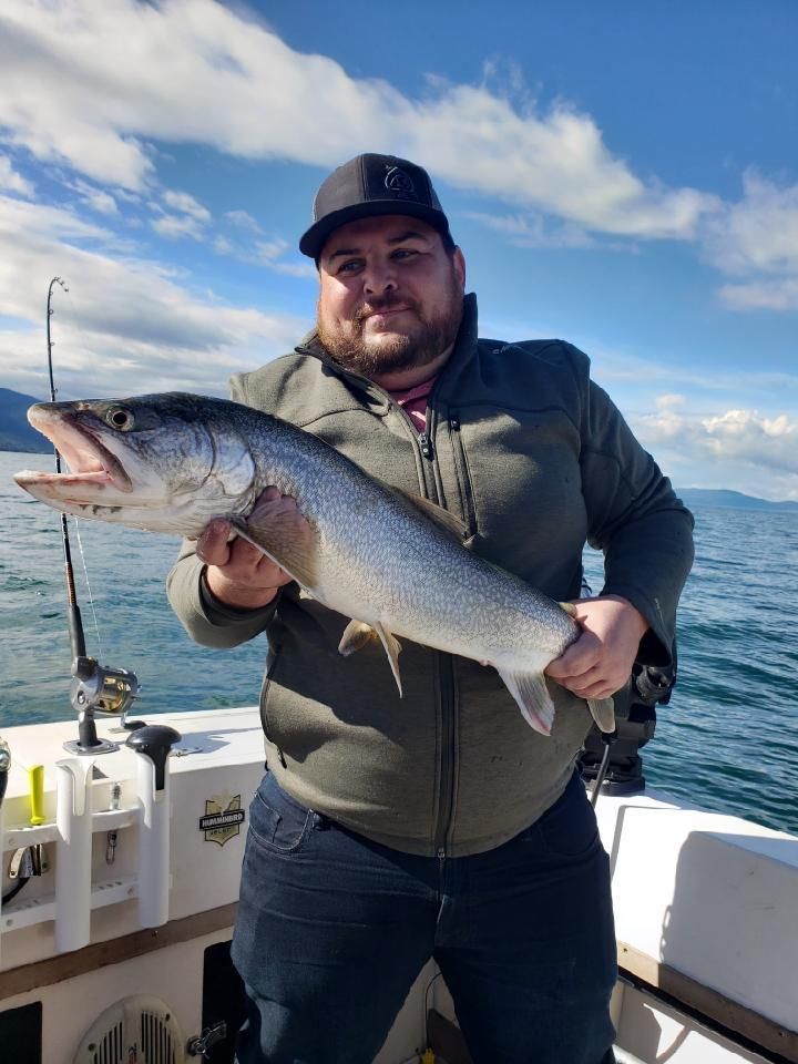 A man is holding a large fish on a boat.