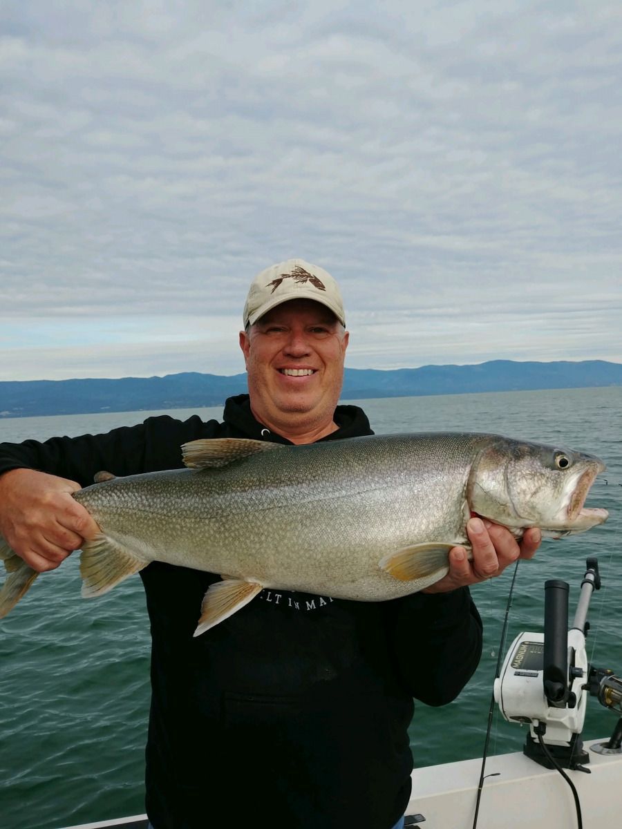 A man is holding a large fish on a boat