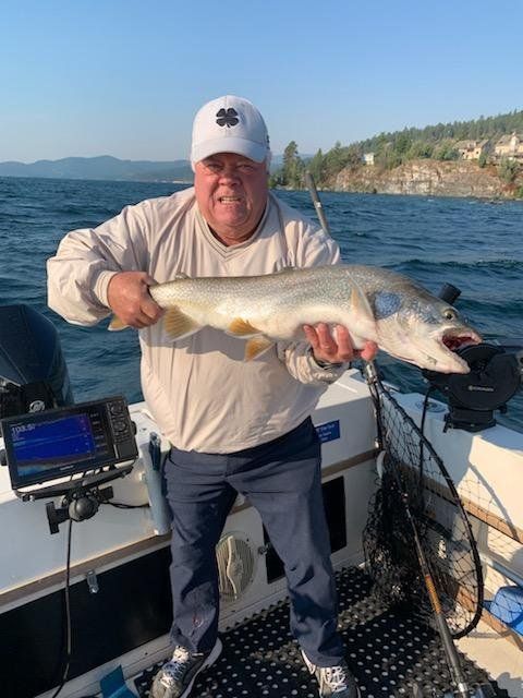 A man is holding a large fish on a boat.