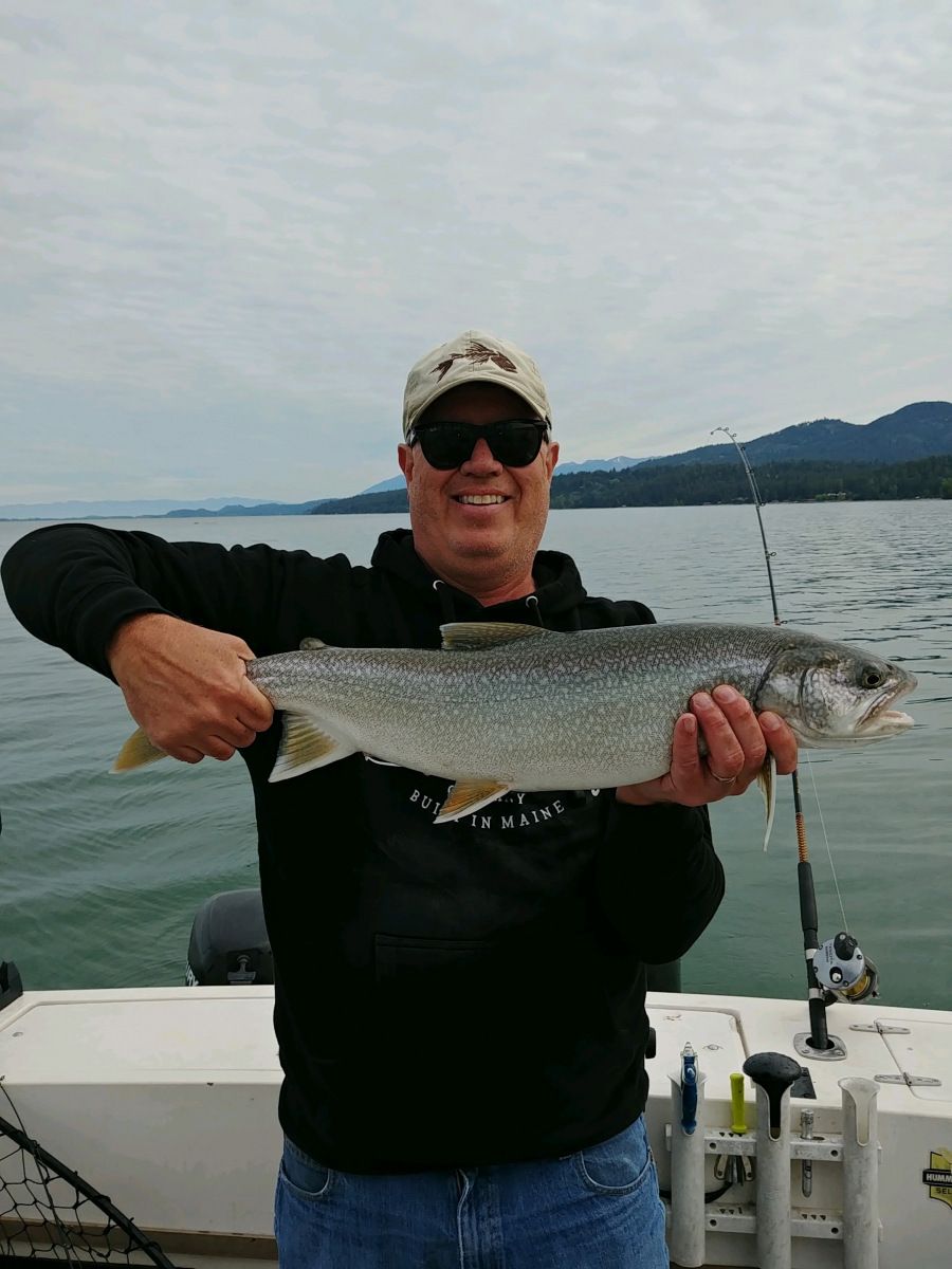 A man is holding a large fish on a boat