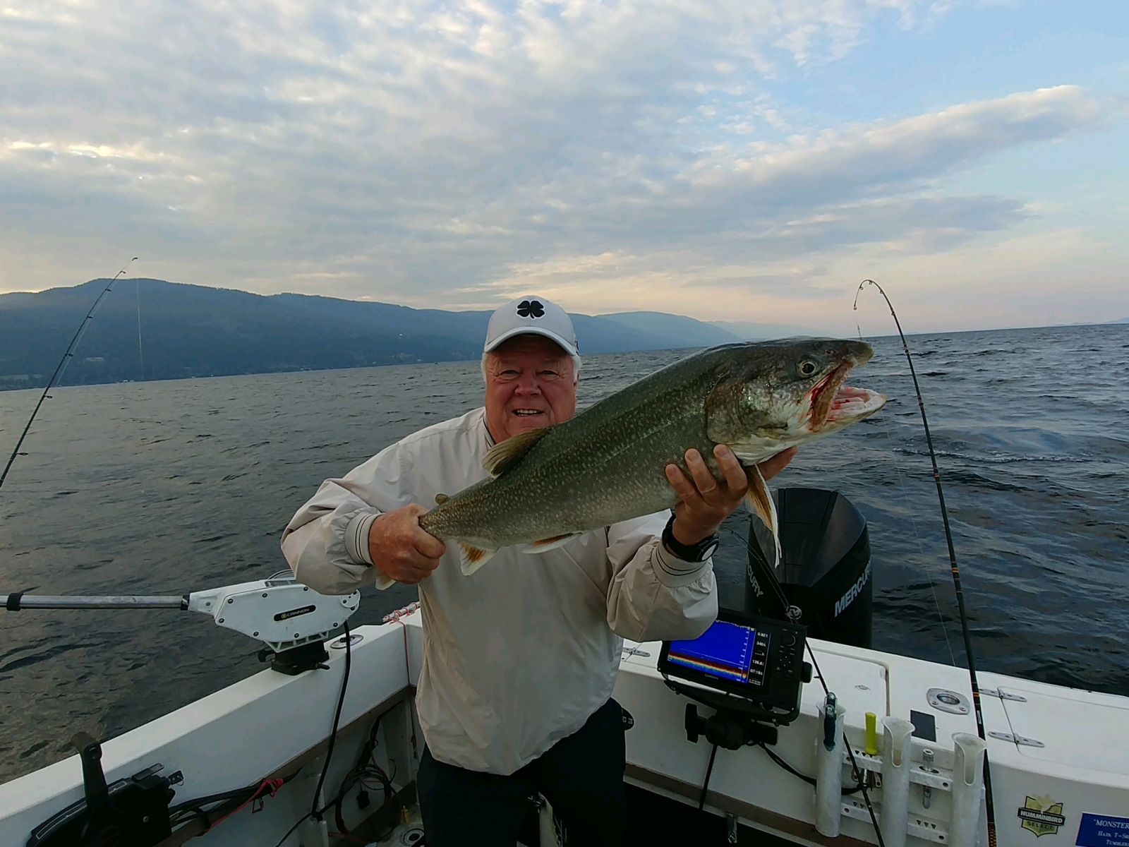 A man is holding a large fish on a boat.