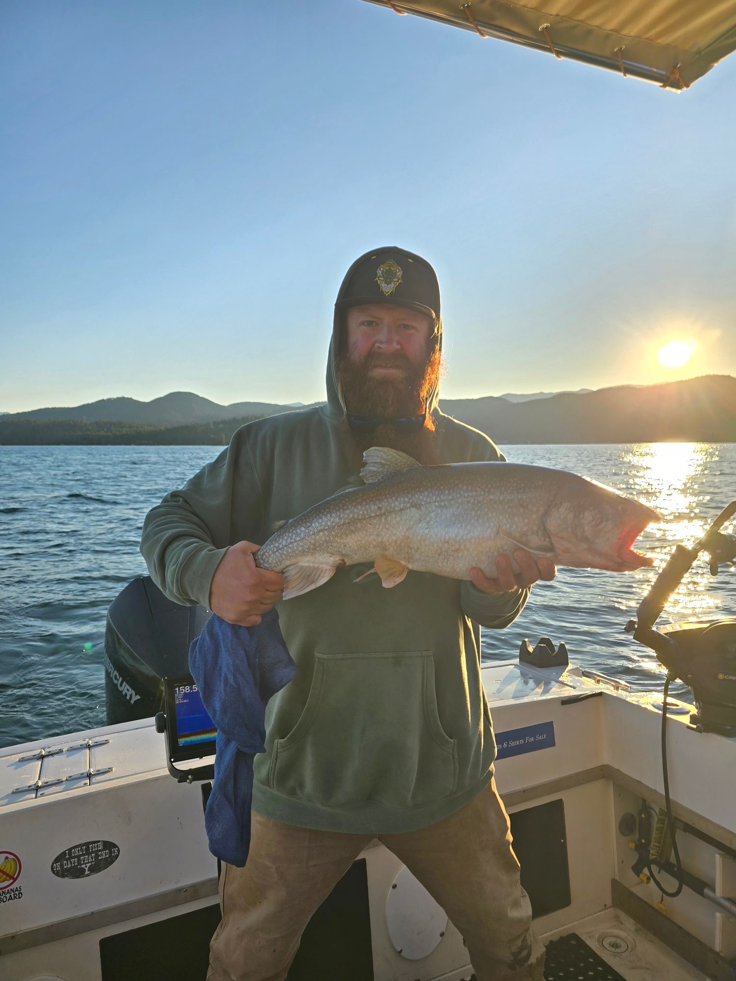 A man is holding a large fish on a boat.