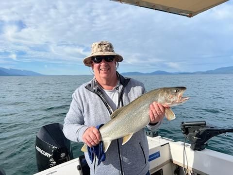 A man is holding a large fish on a boat.