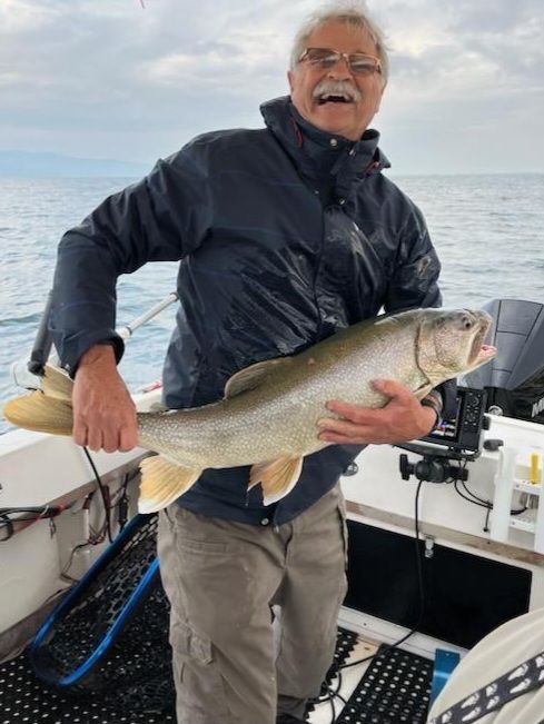 A man is holding a large fish on a boat