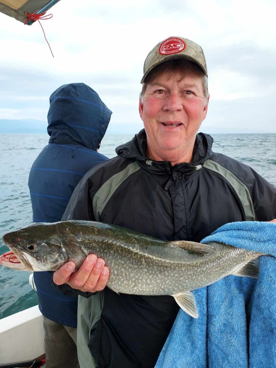 A man is holding a fish in his hands on a boat