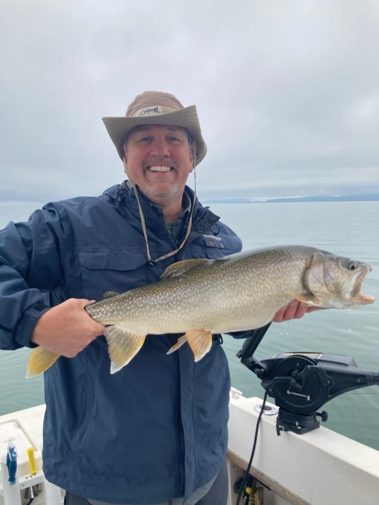A man is holding a large fish on a boat.